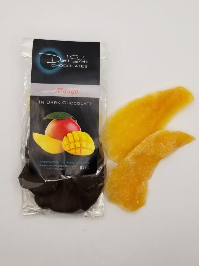 a package of dried mango dipped in dark chocolate, with 2 pieces of dried mango beside the package